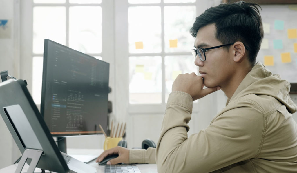 man with jacket looking at laptop screen to learn SEO