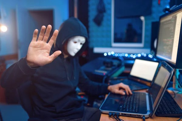 man with mask sitting in front of laptop man with mask sitting in front of laptop